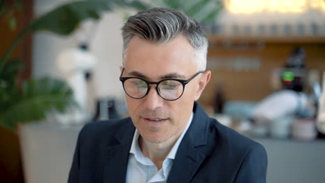 Attractive-Business-Man-With-Glasses-Looks-Directly-Into-The-Camera-And-Smiles