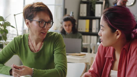 Female-Mentor-Working-with-Young-Asian-Trainee-in-Office