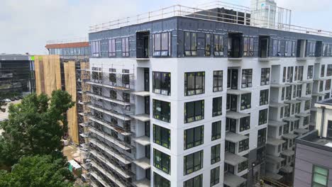 brand-new-building-still-in-construction,-7-floors-with-out-siding,-been-built-aerial-view-close-to-the-walls-windows-installed