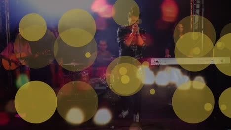 Animation-of-dots-moving-over-biracial-male-singer-on-concert