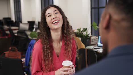 Two-happy-diverse-creative-colleagues-in-discussion-in-casual-office,-slow-motion