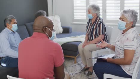 Group-of-diverse-senior-friends-in-face-masks-having-support-meeting