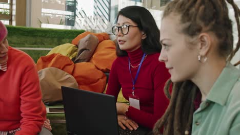 Confident-Businesswoman-In-Casualwear-Holding-Touchpad-While-Sitting-By-Table-In-Front-Of-Two-Colleagues-And-Presenting-New-Plan-1