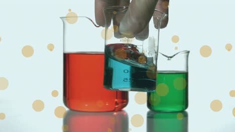 Animation-of-spots-over-hand-holding-beaker