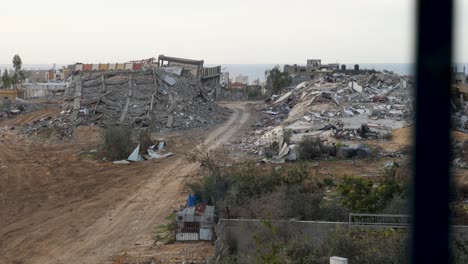 Destroyed-buildings-in-Gaza,-view-through-the-window,-establishing-war-footage