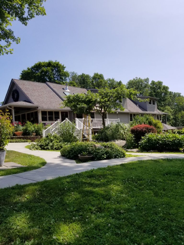 exterior of landscaped inn and white porch at Bernetta's Place Inn by the Lake