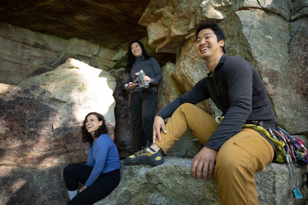 three mountain climbers taking a break among the rocks