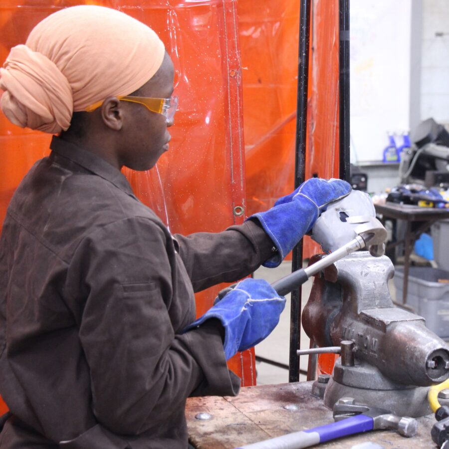 LIFT participant uses hammers to shape metal pieces.