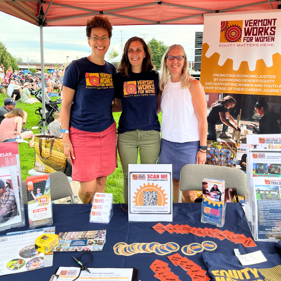 VWWers pose for a photo behind a table at a community event