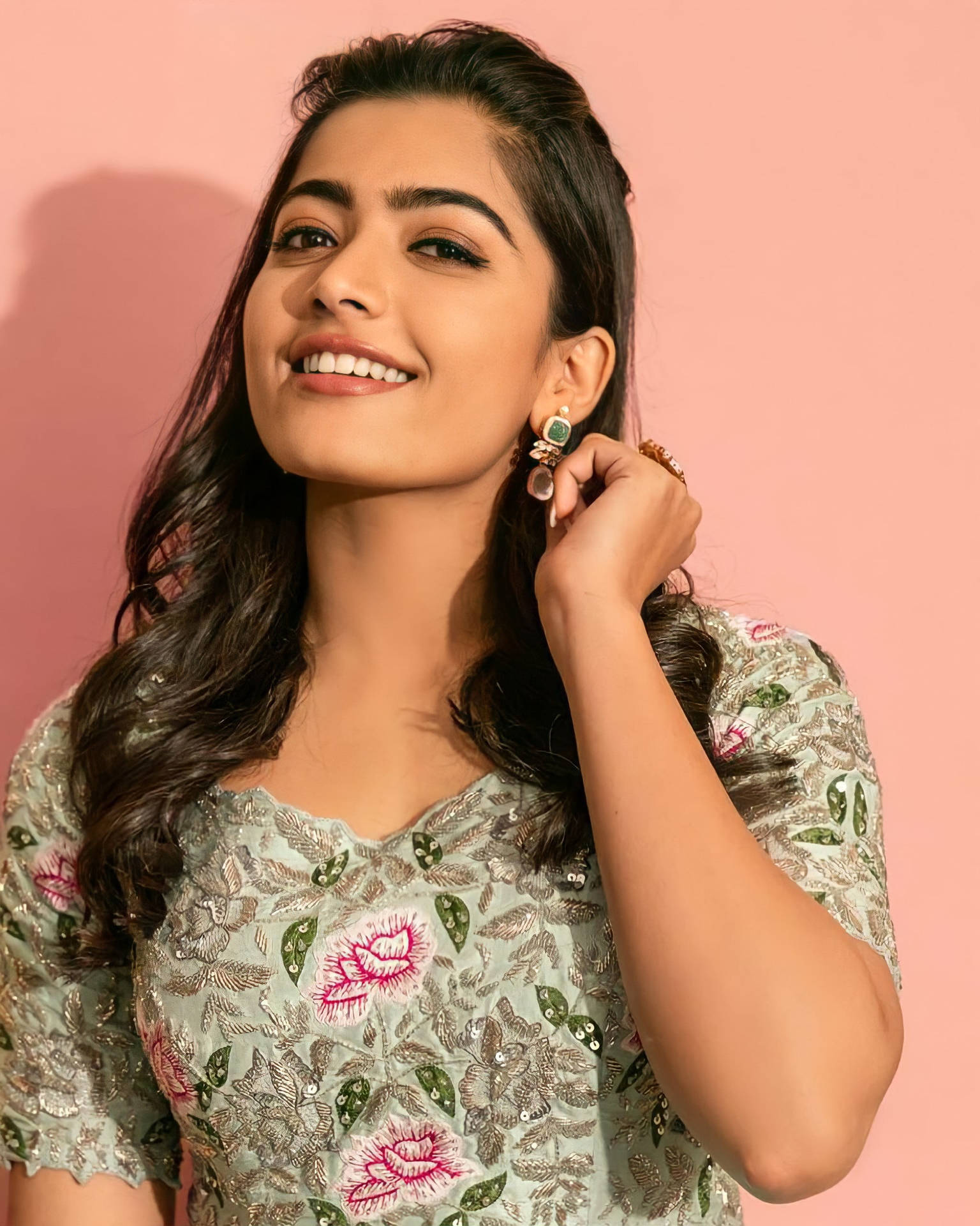 Elegant Rashmika Mandanna in High Definition against a pink backdrop Wallpaper