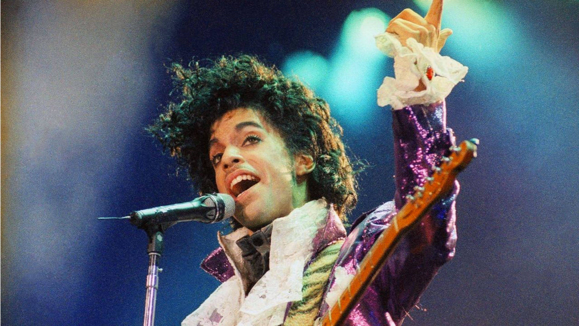 The Iconic Singer, Prince Playing A Guitar On Stage Wallpaper