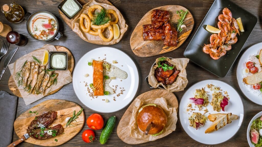 Assorted dishes top view pork ribs, beef steak, salmon steak, chicken wings, Burger with meat, squid Rings