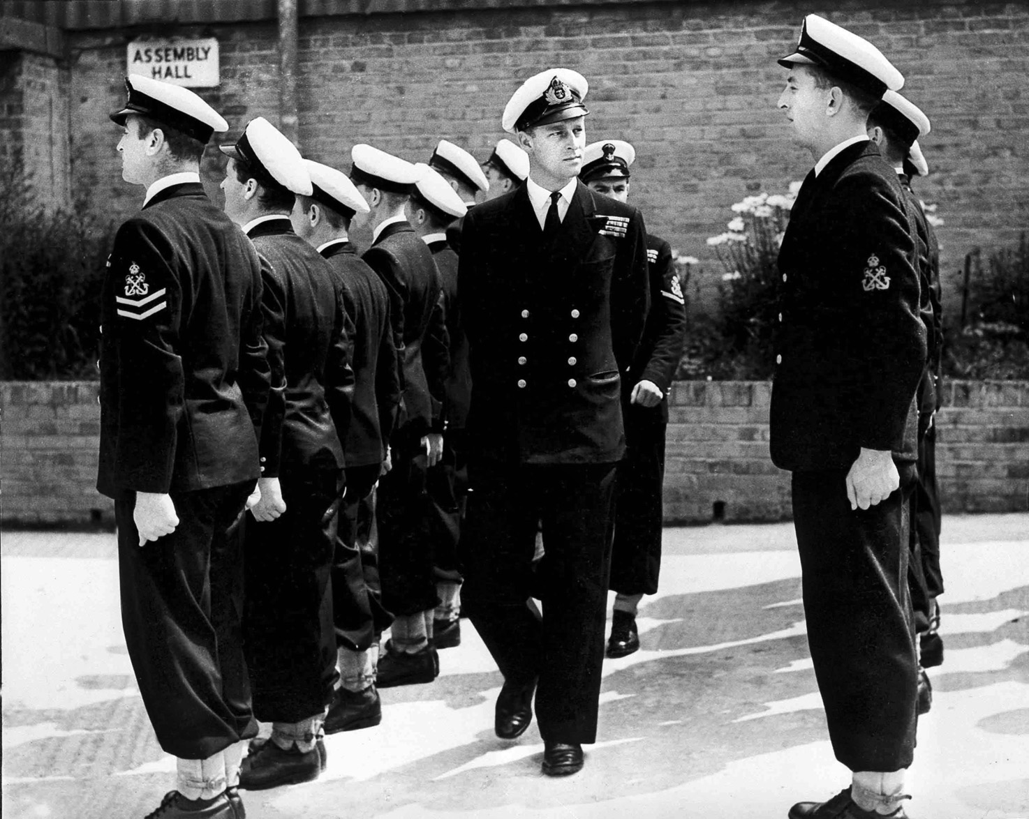 Prince Philip (center) inspects sailors assembled in ranks at the Petty Officers’ Training Center, Corsham, England, in 1947. 