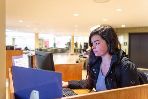 A student working at a library computer on campus