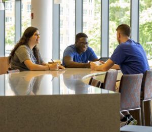 3 Worcester State students having a conversation at the dining hall