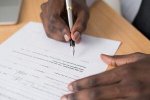 A person singing a form with a pen