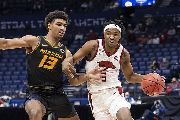 Arkansas' JD Notae (right) drives around Missouri's Mark Smith during an SEC Tournament game Friday, March 12, 2021, in Nashville, Tenn. (Photo via SEC Pool)