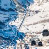 Scenic valley view of snow-covered mountains and village in Val d'Isère ski area.