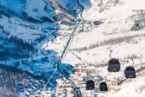 Scenic valley view of snow-covered mountains and village in Val d'Isère ski area.