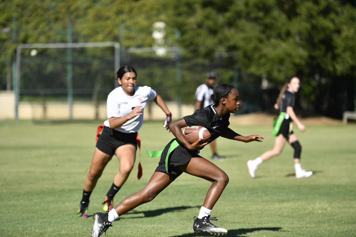 Layla R. '27, center, rushing the ball in a game. 