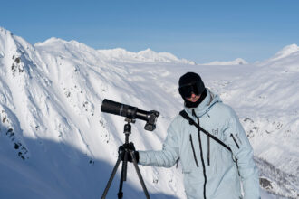 Person next to tripod on mountain top