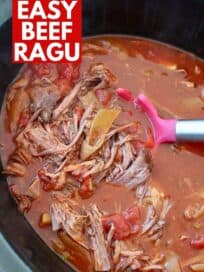 shredded beef ragu in slow cooker with serving spoon