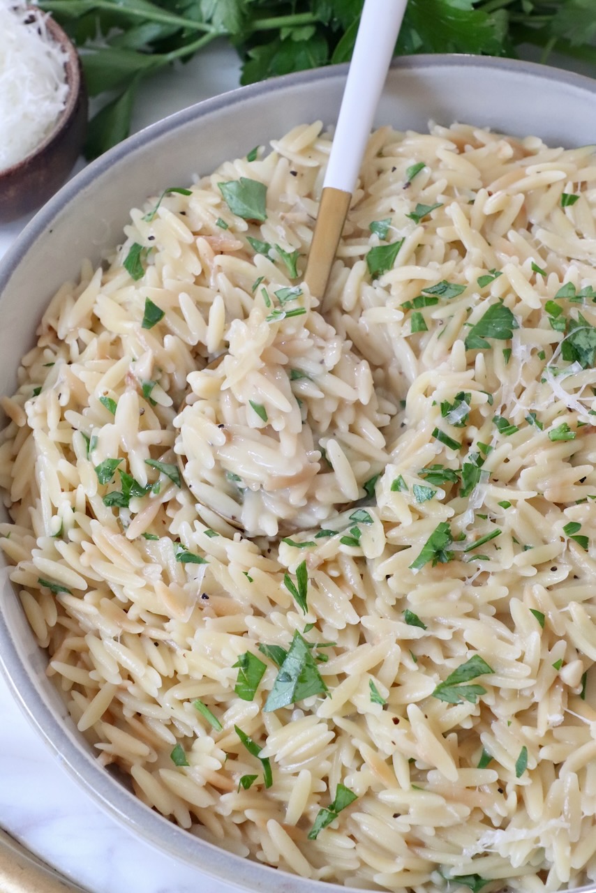 cooked orzo in a bowl with a spoon