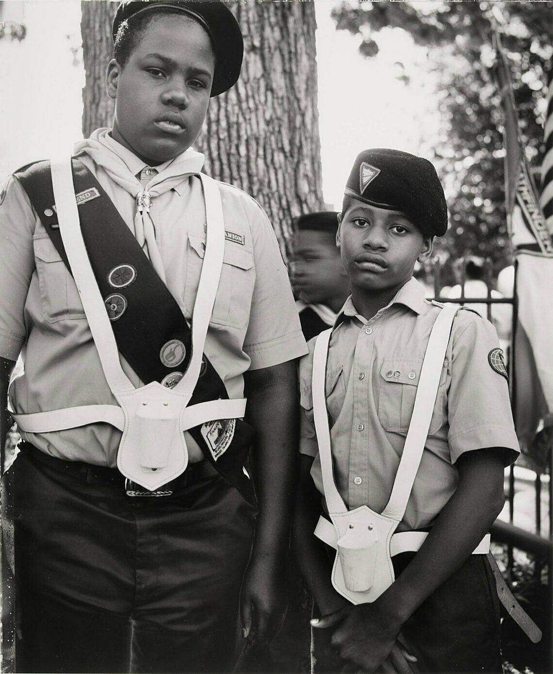 A black and white photograph by Dawoud Bey. Two young African American boys wear scout uniforms, with somber faces.