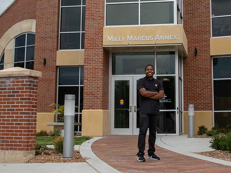 Director of Admissions Bobby Gandu in front of the new Milly Marcus Annex to the Marcus Welcome Center