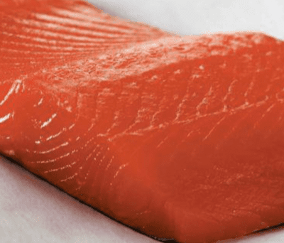 Raw salmon fillet on white background.