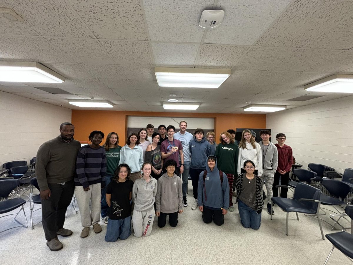 The crew team poses with Evan Hansen for a picture. Hansen visited the team to talk about his story as an olympic medalist. (Courtesy Mary Roberts)