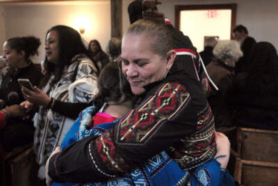 Jessie Little Doe Baird, front right, hugs a member of the audience following the &quot;We Gather Together&quot; celebration at the Old Indian Meeting House, in Mashpee, Mass., Nov. 18, 2017. (Steven Senne/AP)