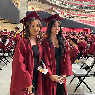 Two senior girls in cap and gown during graduation