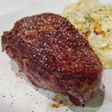 filtet mignon with potatoes on a white plate