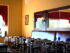 Restaurant tables and chairs with wood-framed mirrors on the wall.