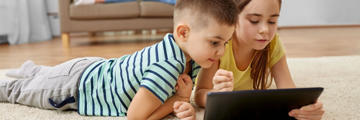 A brother and a sister playing ABCmouse on an i-pad.