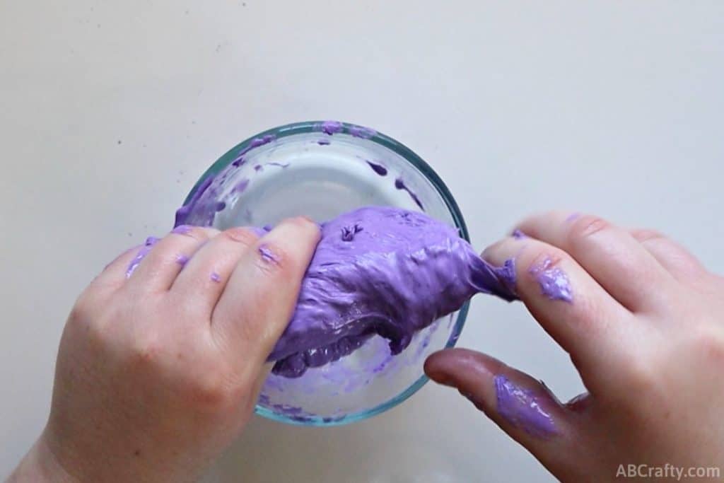 using hands to mix purple slime