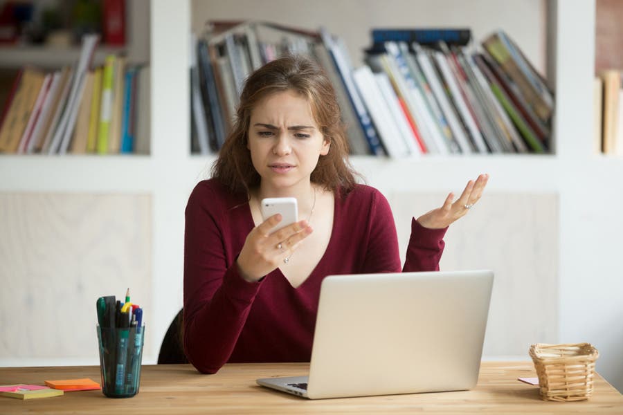 Woman reading hate comments on her phone