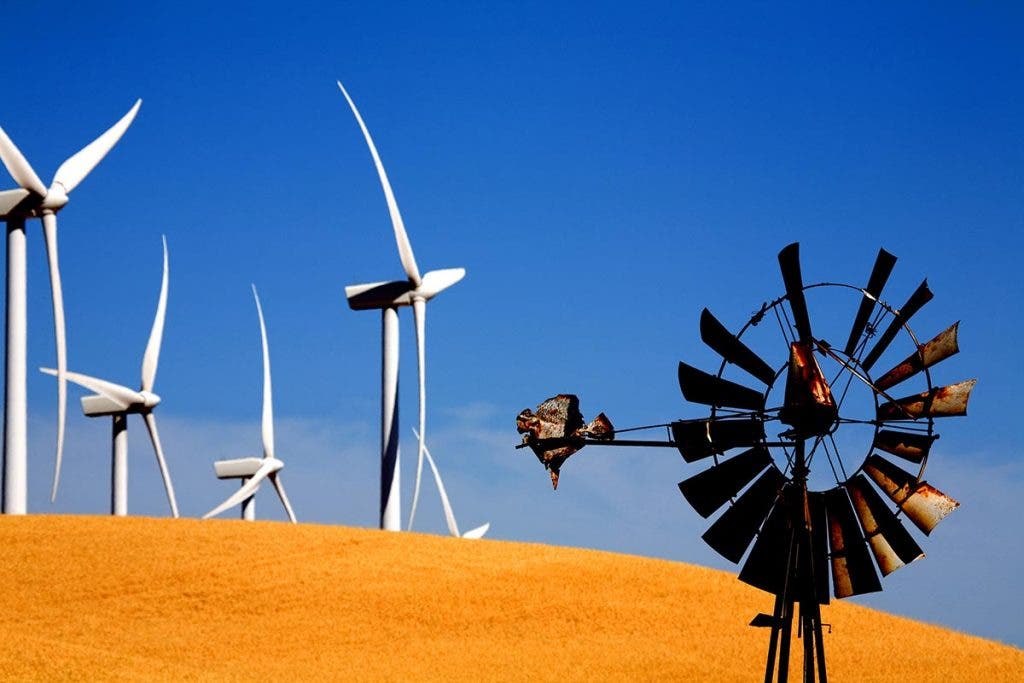 old and new windmills on land