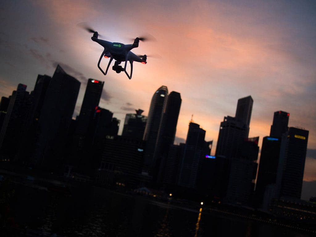 drone flying at night over city skyline