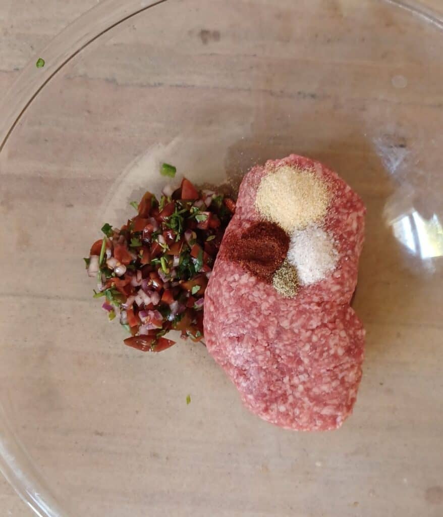 Ground beef, pico de gallo, garlic powder, chipotle powder, salt, and pepper in large glass bowl