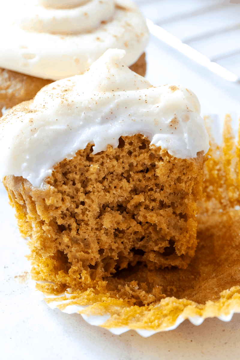 half of a pumpkin cupcake with frosting on top