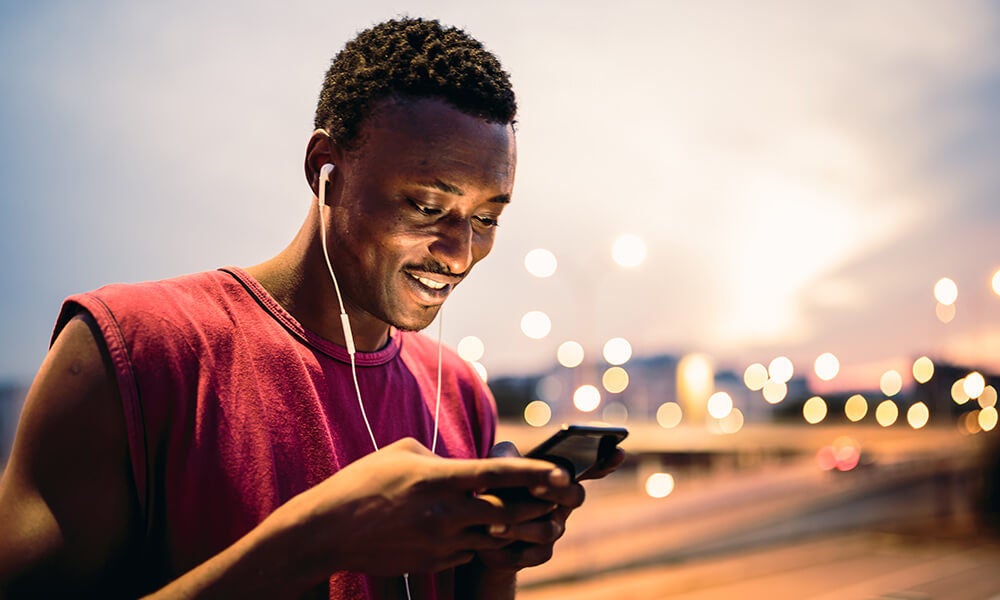 Running guy using his phone outside at night