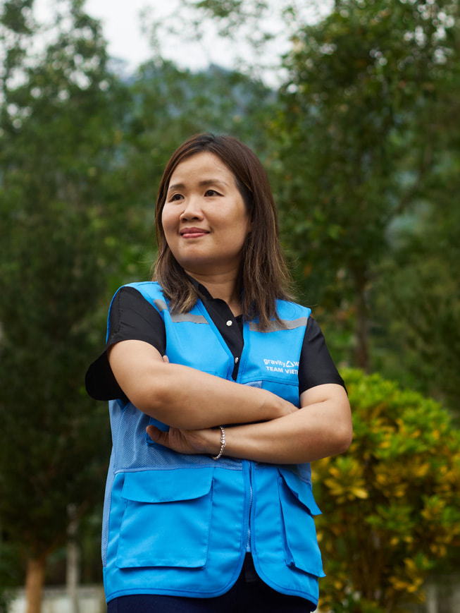 Et portræt af Chu Thanh Hoa, som står udenfor iført en blå Gravity Water-vest.