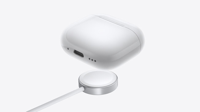 AirPods 4 are shown with an Apple Watch charger.