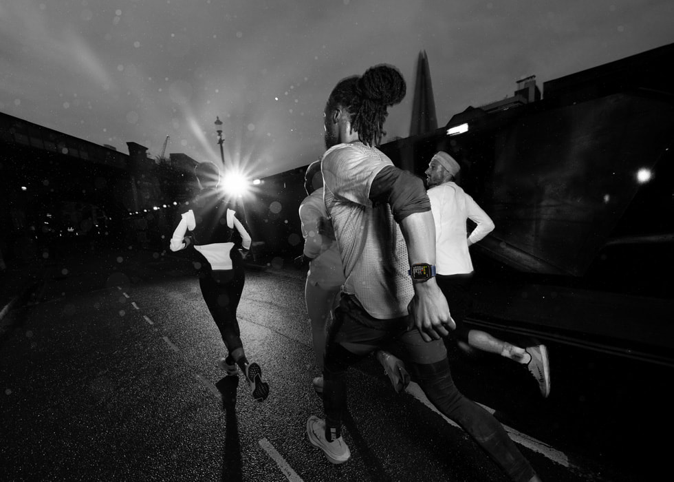 A photo of runners wearing Apple Watch Ultra 2 at night. 