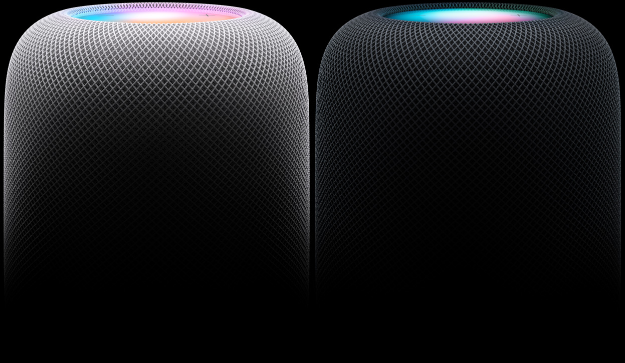 Side view of two HomePod speakers positioned side by side — the left speaker is White, the right speaker is Midnight