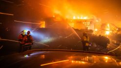 Fire fighters try to contain a house fire. 