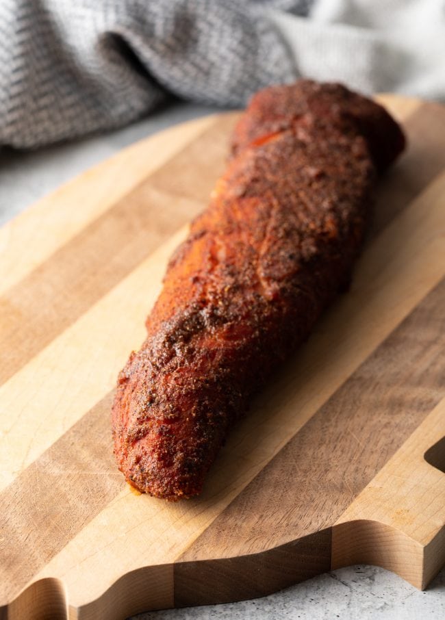 whole smoked loin on a cutting board resting