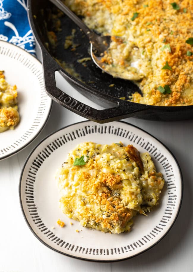 Top down view servings on casserole with zucchini and cheese on a plate.